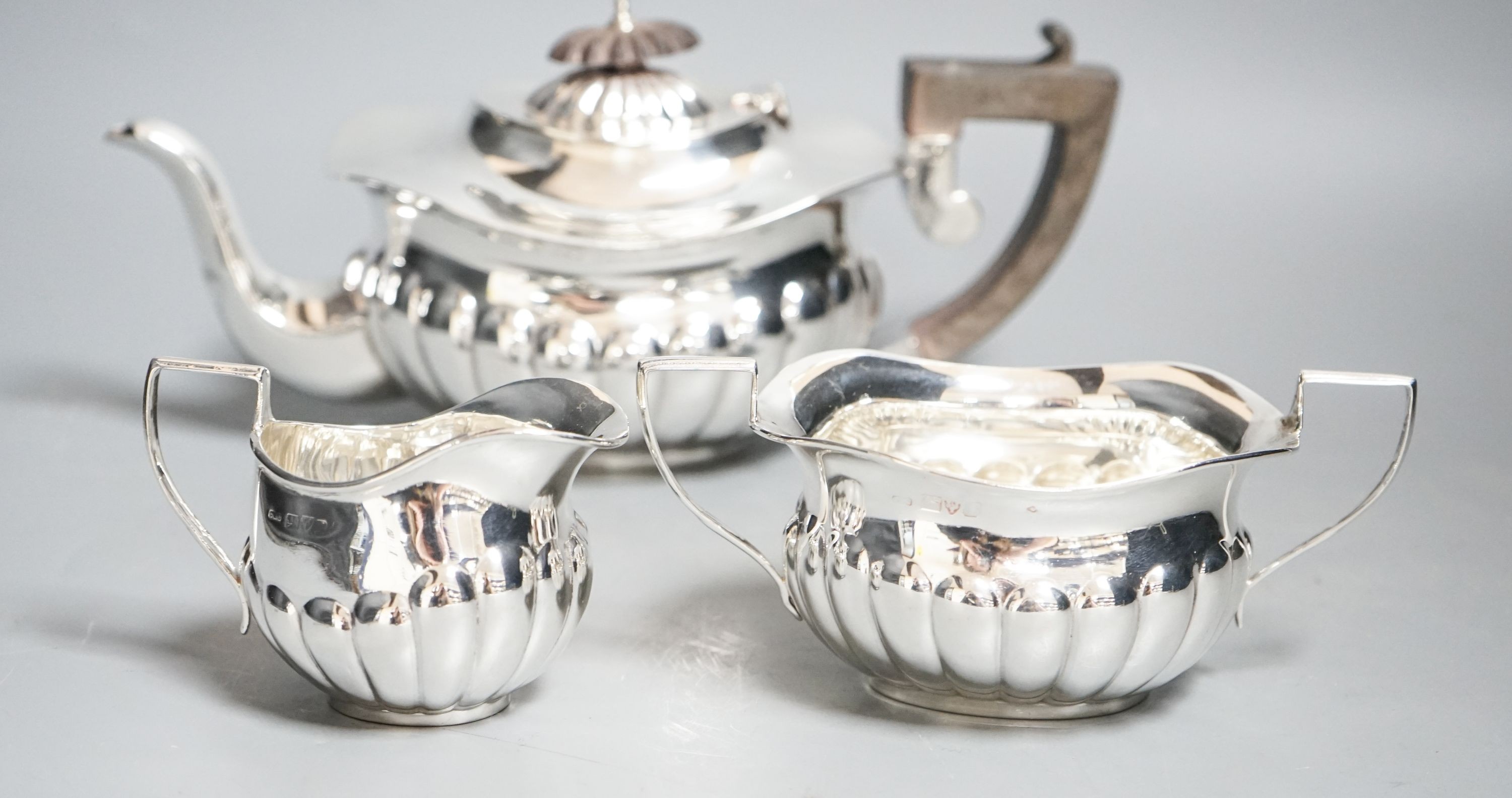 An Edwardian demi-fluted silver three piece bachelor's tea set, Chester, 1909, gross 15.5 oz.